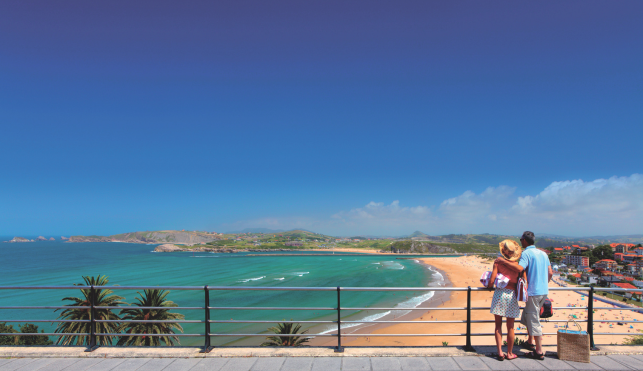 An image of a couple looking at a beach in suances
